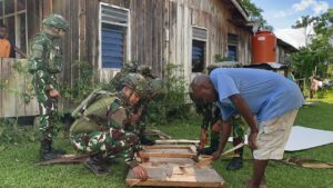 mbminvestigasi.com | Asah, Asih, Asuh di Tanah Papua, Satgas Yonif 521/DY Perbaiki Pintu yang Rusak dan Berikan Bantuan Kitab Suci kepada Tokoh Agama di Kobakma