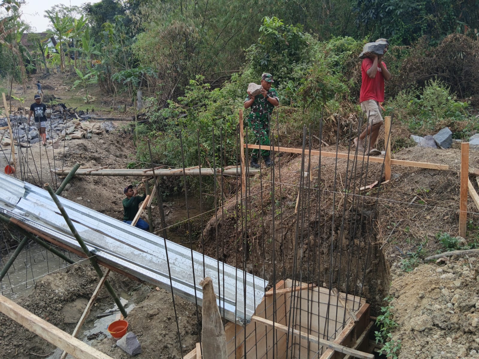 mbminvestigasi.com | Babinsa Kawal Proyek Penghubung Dua Desa Demi Dongkrak Perekonomian Warga